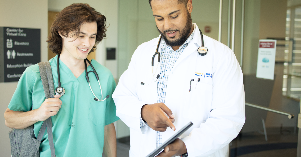 Medical student and his attending study a tablet during clinical rotations. 