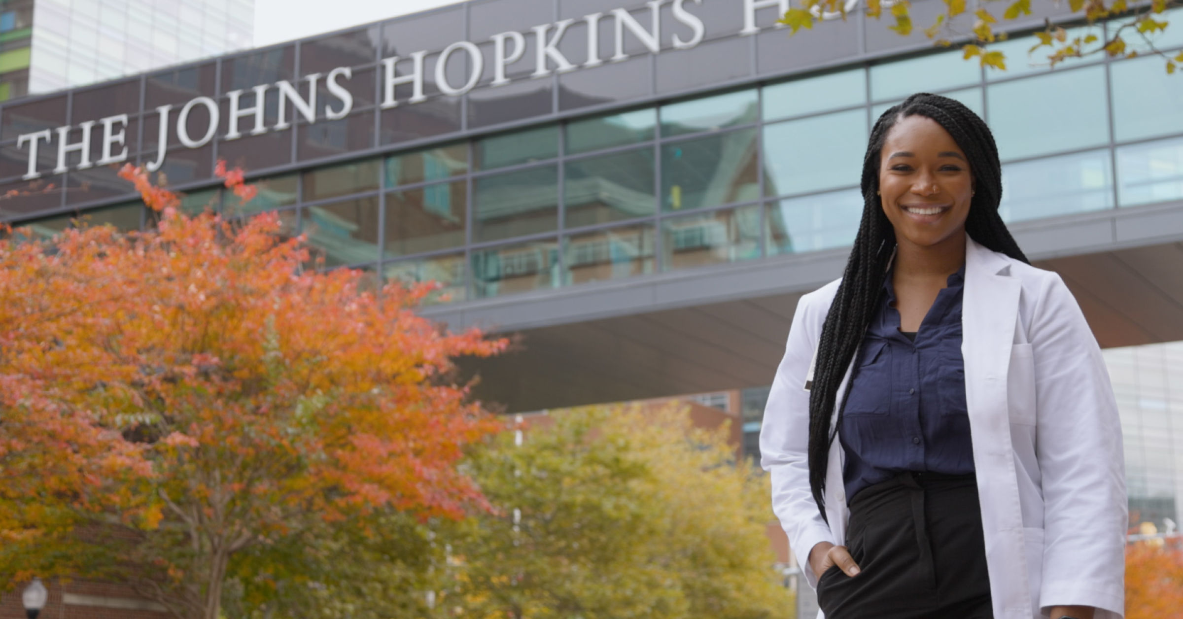 Dr. Osose Oboh, former medical student and current intern, standing in front of Johns Hopkins Hospital.