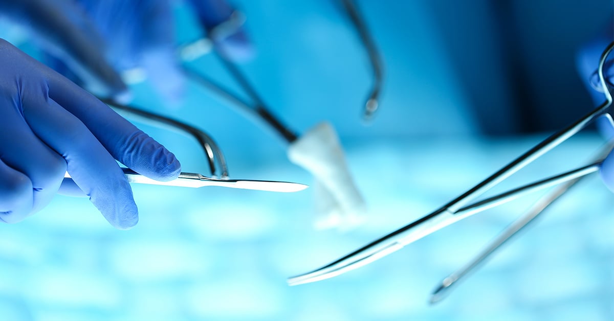 Closeup of surgeons' hands holding surgical tools in the OR