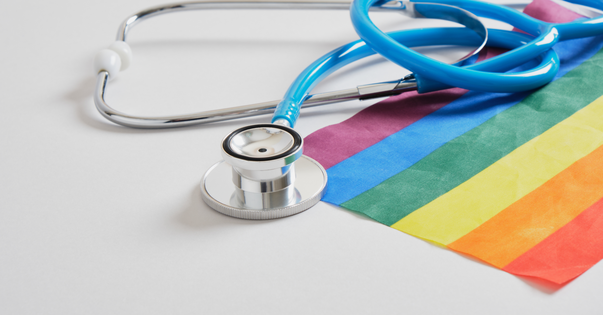 Ein Stethoskop liegt auf einer Regenbogenfahne. Der Weg in eine diskriminierungsfreie Medizin im AMBOSS-Blog.
